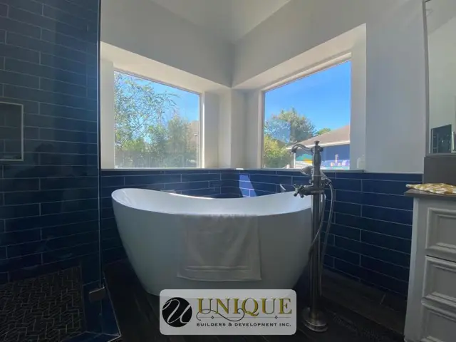 Freestanding tub under a window in a remodeled bathroom