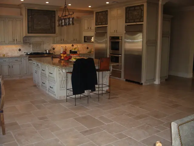 Kitchen with cream cabinetry, stone island and stainless appliances